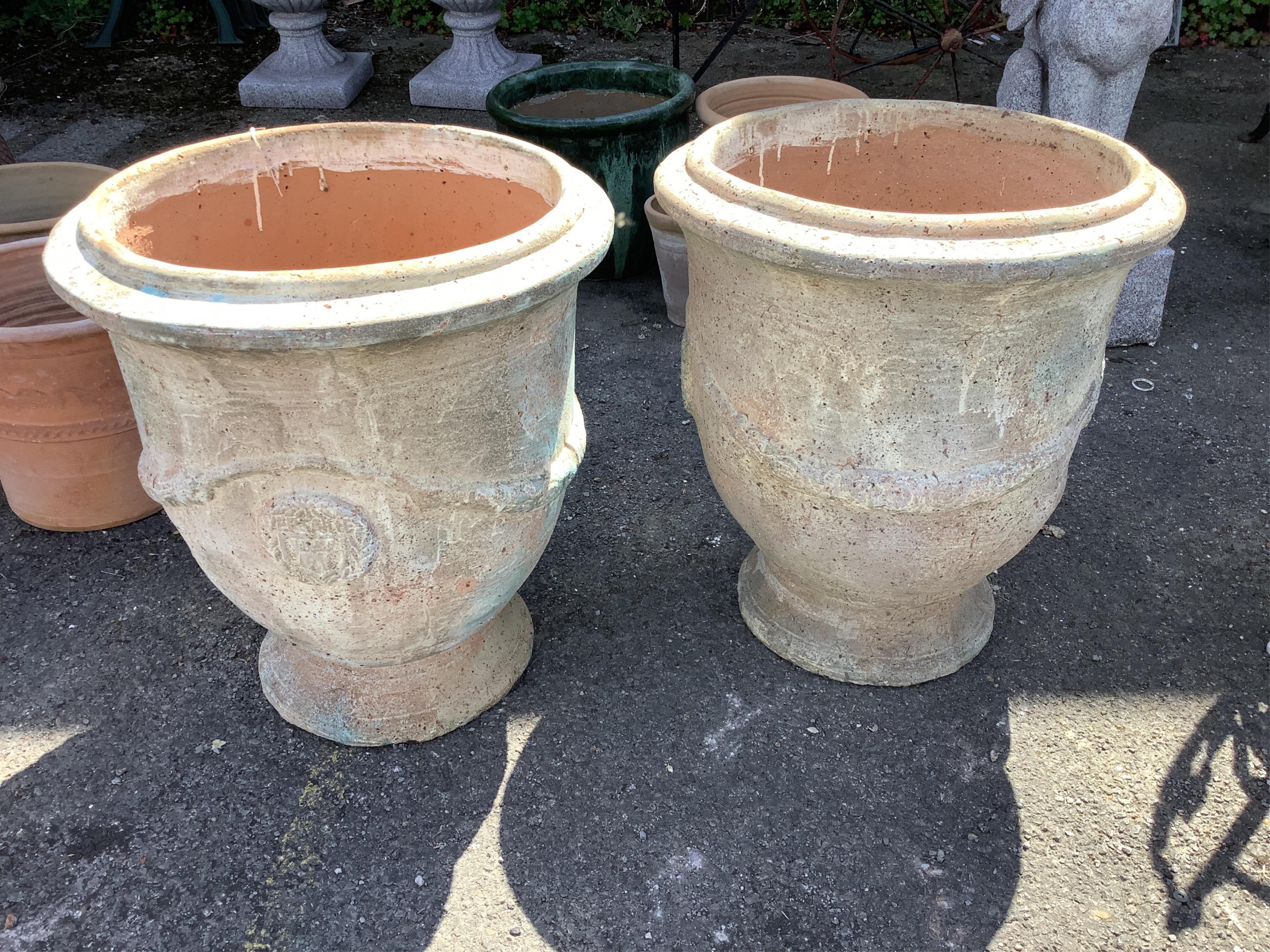 A pair of large circular earthenware garden planters, diameter 61cm, height 68cm